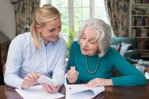  Woman Helping Senior Neighbor With Paperwork
